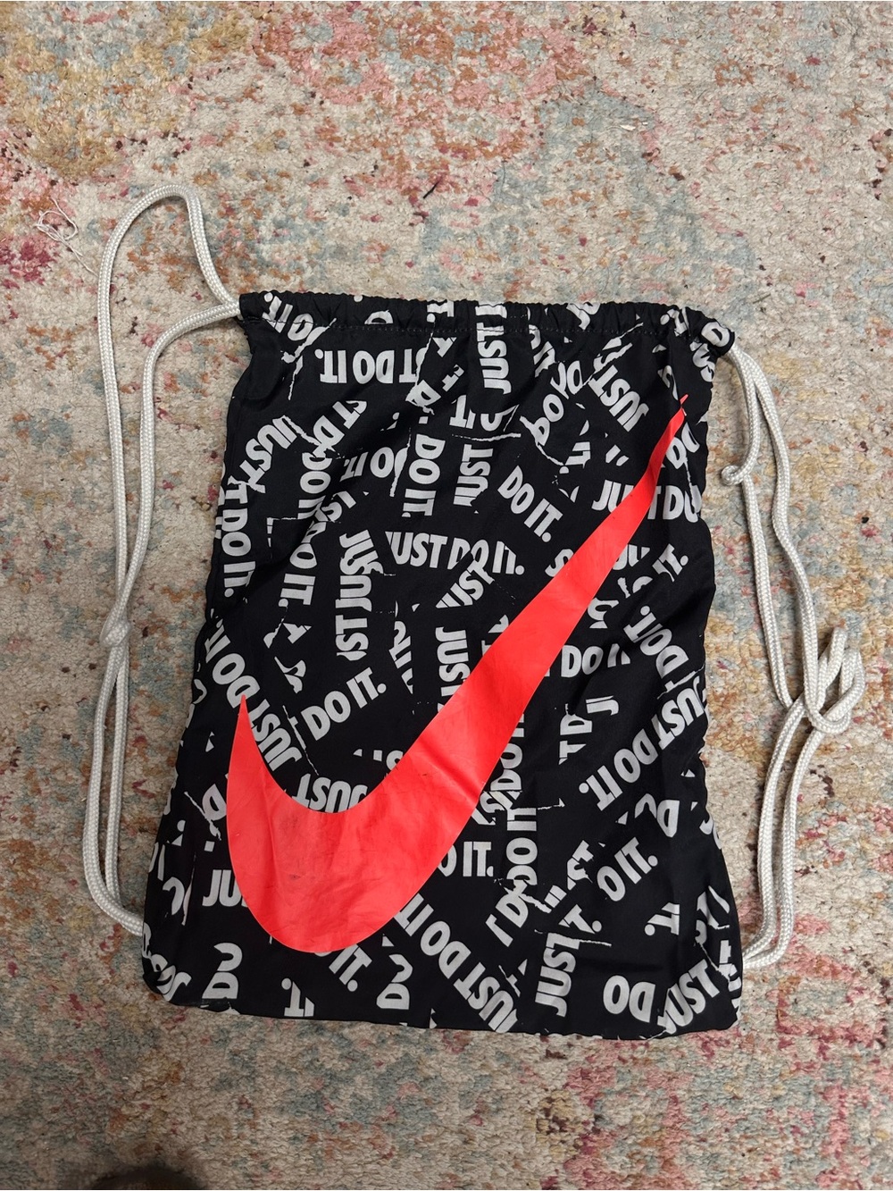Nike Black Drawstring Bag with Red Swoosh and White Logo Print